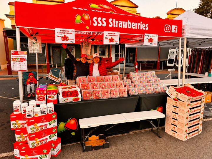 The SSS Strawberries market stall stacked with punnets of fresh strawberries